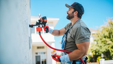 professional painter painting a living room wall with a roller, modern home interior