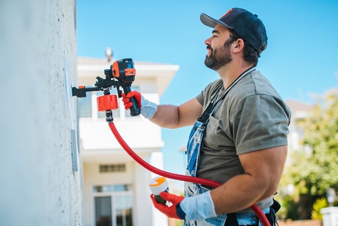 professional painter painting a living room wall with a roller, modern home interior